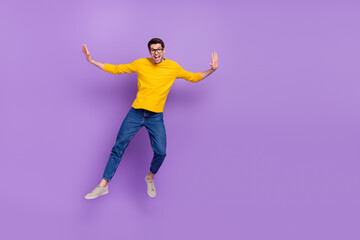 Fototapeta na wymiar Full body photo of smiling handsome youth man jump up enjoy summer vacation isolated on violet color background