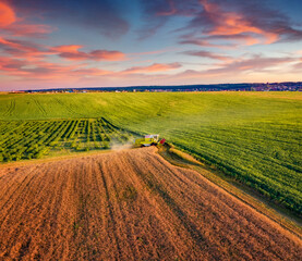 Beautiful summer scene of combine harvester on the field of wheat. Captivating summer view from...