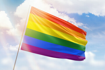 Sunny blue sky and a flagpole with flag of lgbt pride