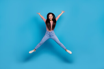 Full length photo of pretty excited woman wear striped shirt jumping high like star smiling...