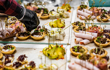 Chef hand is in process of Preparing catering food on table