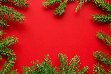 Fototapeta na wymiar Christmas red background from green fir branches, frame, top view