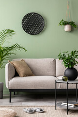 The stylish composition at living room interior with green wall, design gray sofa, coffee table,...