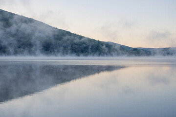 Obraz na płótnie Canvas Morning fog over. a mountain lake, landscape vacation theme, summer.