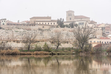 Fototapeta na wymiar View of the city of Zamora with San Isidoro church and the Douro river in a foogy day.