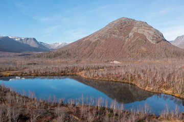 Blue mountain lake on the background mountain picks in polar autumn. Landscapes of Northern Nature. Nature regions of Russia