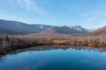 Blue mountain lake on the background snow-capped mountain picks in polar autumn. Landscapes of Northern Nature. Nature regions of Russia. Russian north.