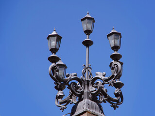Fototapeta na wymiar Three street lamps made of black metal.