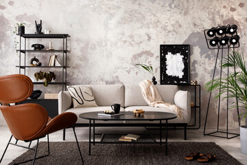 The stylish compostion at living room interior with design gray sofa, armchair, black coffee table, lamp and elegant personal accessories. Loft and industrial interior. Template. .