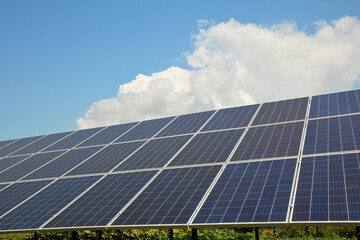 Solar panels against blue sky and white cloud with copy space.