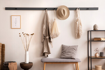 The stylish composition of cosy entryway with grey bench, coffee table, hanger and personal...
