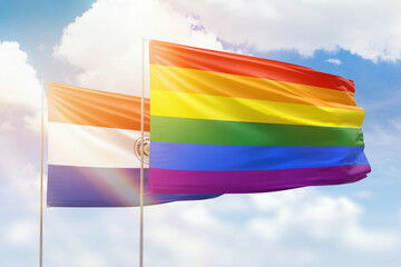 Sunny blue sky and flags of lgbt and paraguay