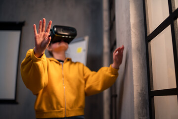 Schoolgirl wearing virtual reality goggles at school in computer science class