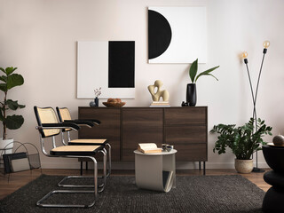 The stylish compostion at living room interior with mock up, wooden commode, rattan chairs and elegant personal accessories. White wall with modern image. Cozy apartment. Mock up poster..