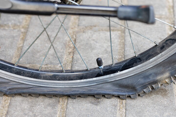 A punctured bicycle wheel on the background of paving slabs.