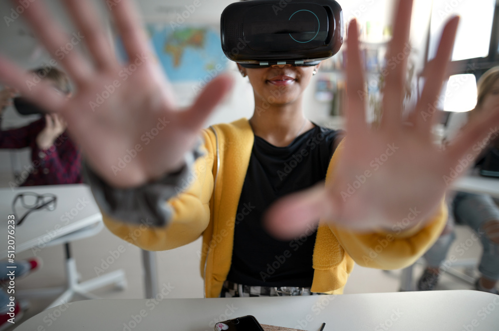 Wall mural close-up of student wearing virtual reality goggles at school in computer science class.
