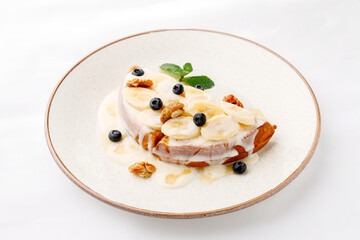 Waffles with sweet sauce and fruit on a white background