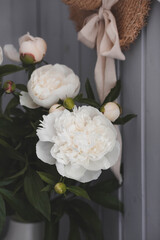 A beautiful white bouquet of peonies in the sunlight on a black table. The interior of a country house in the style of Provence. The concept of home comfort and decor in the house.