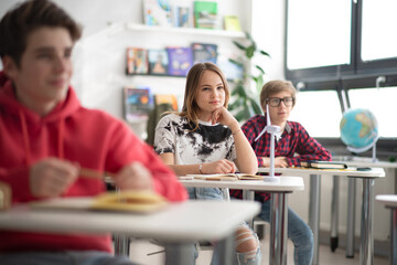 Students paying attention in class, sitting in their school desks.