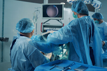 Doctors performing hysteroscopy procedure in the operating room