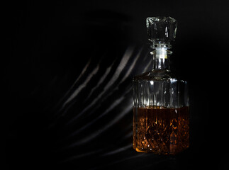 Glass vessel, a decanter with a light brown liquid poured in half closed with a glass stopper