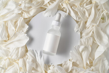 A jar of serum on the petals of a peony