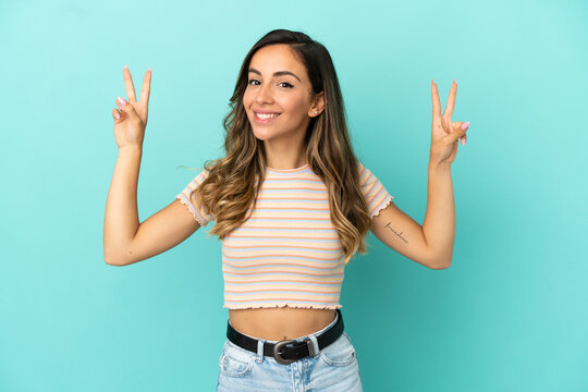 Young woman over isolated blue background showing victory sign with both hands