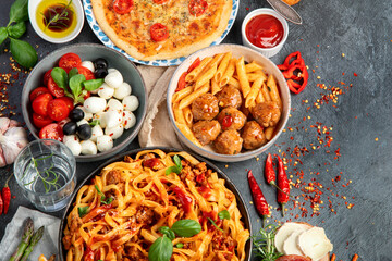 Italian food assortment on dark background.