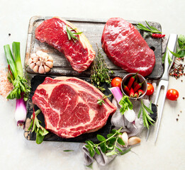 Variety of raw beef meat steaks for grilling.