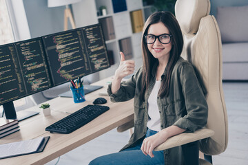Portrait of beautiful cheerful skilled girl tech leader showing thumbup developing web project at...