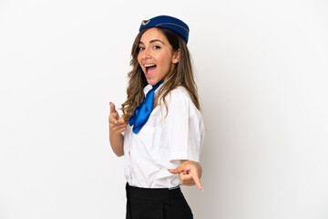 Airplane stewardess over isolated white background pointing to the front and smiling