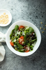 Healthy green salad with tomatoes, pesto and cheese