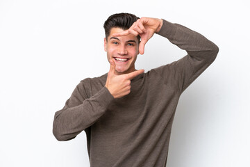 Young handsome caucasian man isolated on white bakcground focusing face. Framing symbol