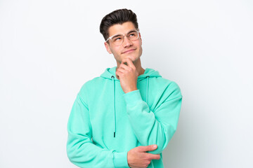 Young handsome caucasian man isolated on white bakcground thinking an idea while looking up