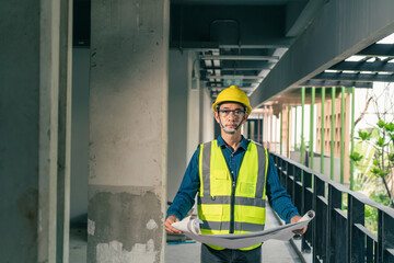 Portrait Asian man Builder holding blueprint in construction site. Foreman inspection working with blueprint in construction site.