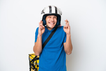 Young caucasian man with thermal backpack isolated on white background with fingers crossing