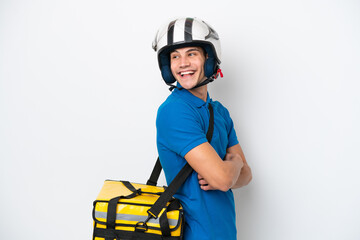Young caucasian man with thermal backpack isolated on white background with arms crossed and happy