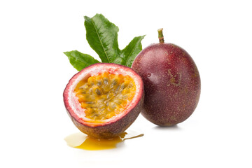 whole and half of passion fruit with green leaf isolated on white.
