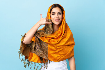 Young Moroccan woman with traditional costume isolated on blue background making phone gesture....