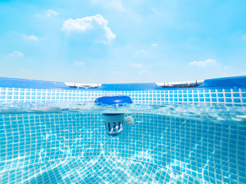 Split underwater view of a chlorine floater dispenser in a pool