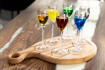 Various colored cocktails in shot glasses.