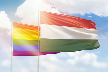 Sunny blue sky and flags of lgbt and hungary