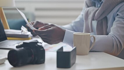 Graphic designer working with color charts, looking at papers, creative work