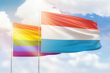 Sunny blue sky and flags of lgbt and luxembourg
