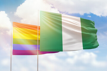 Sunny blue sky and flags of lgbt and nigeria
