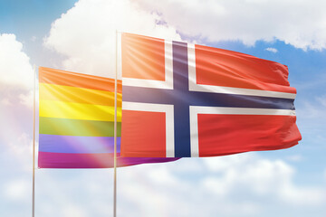Sunny blue sky and flags of lgbt and norway