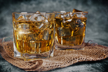 Glasses of whiskey with ice in a rustic setting