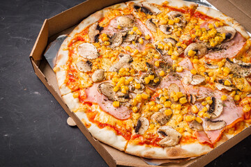 hot delicious traditional italian pizza on a dark stone background