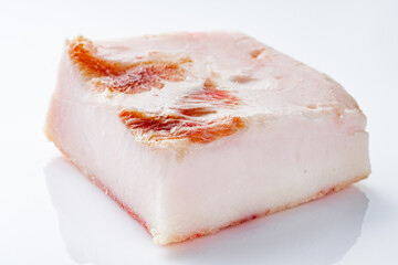 piece of lard on a white acrylic background