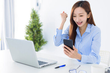 Beautiful asian woman using smartphone, exciting and celebrating with good news of business...